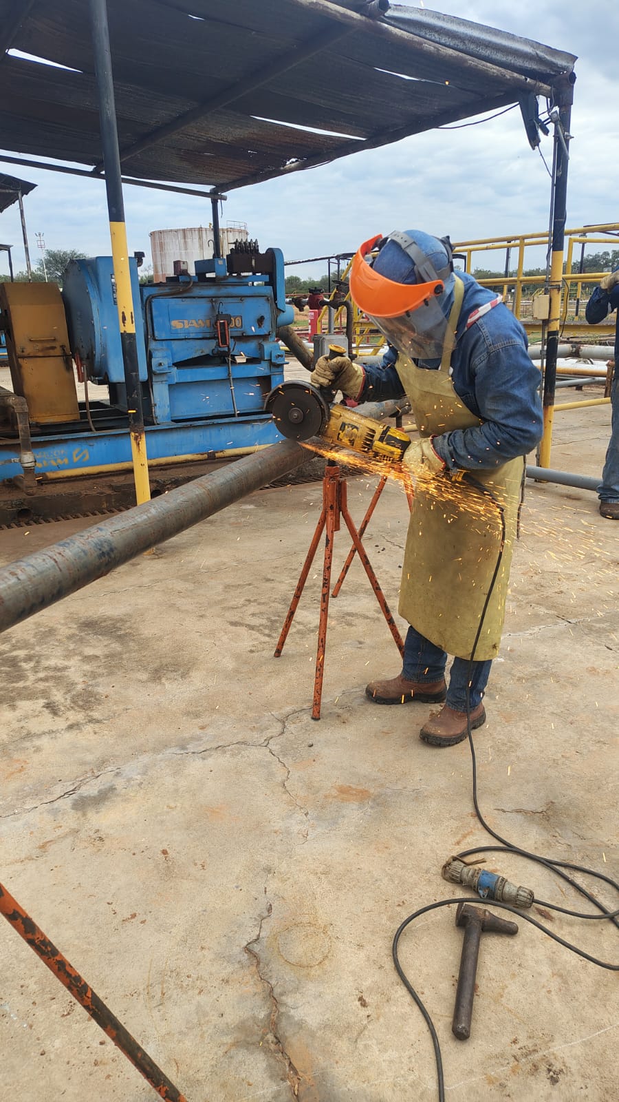 Operario realizando corte con amoladora en locación petrolera