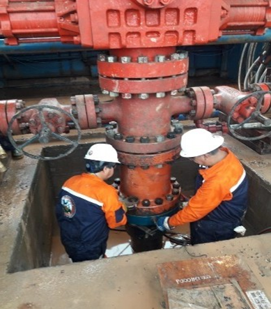 Técnicos ajustando brida de cañería durante corrida de casing